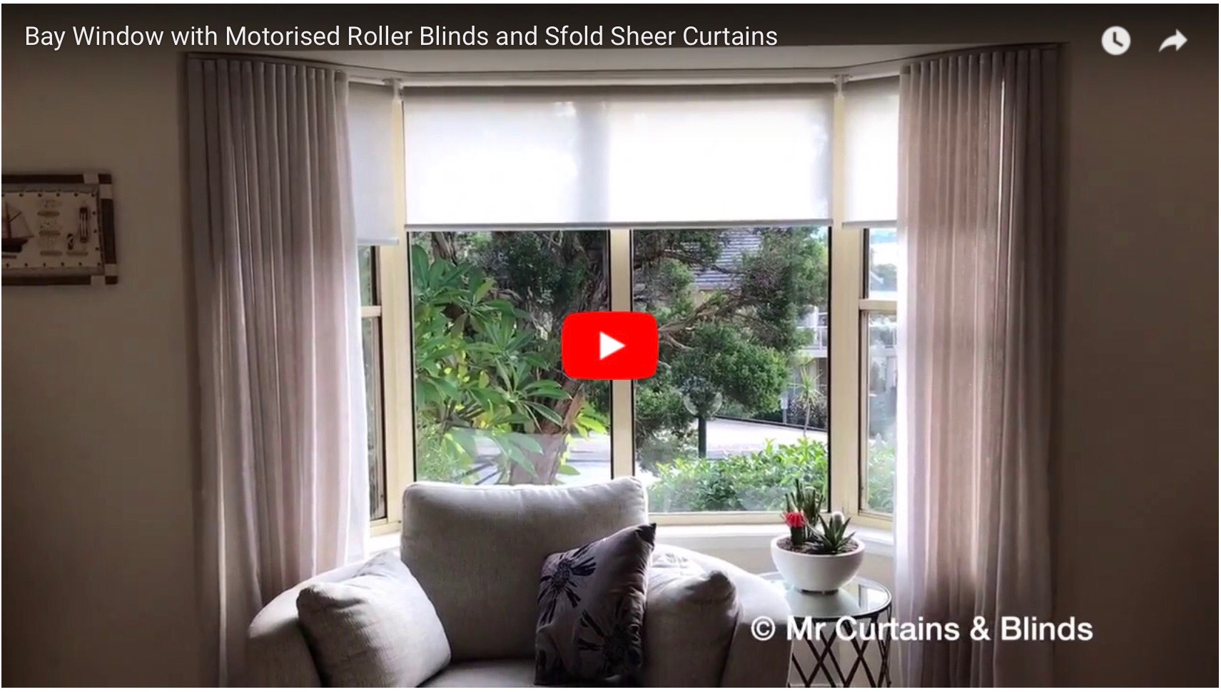 Motorised roller blinds in a bay window with sfold sheer curtains